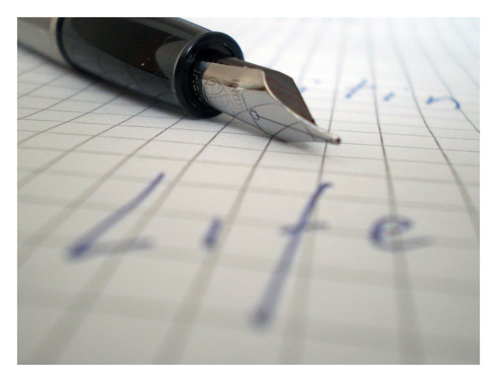 A pen and notebook open on a desk for planning work